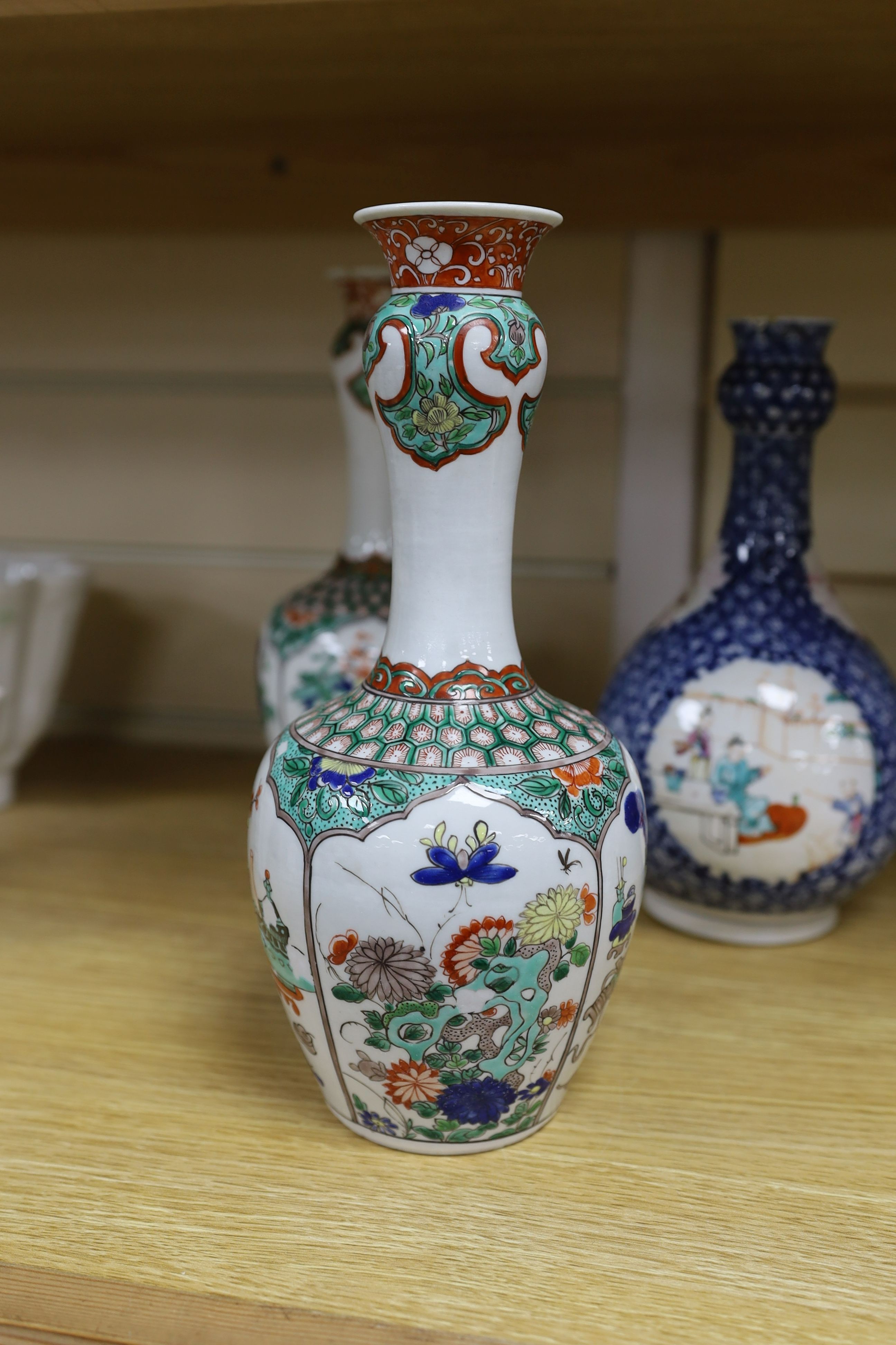 A pair Samson of Paris vases in the Chinese famille verte style and a Chinese Qianlong famille rose garlic neck vase with blue panelling motif, tallest 26cm
